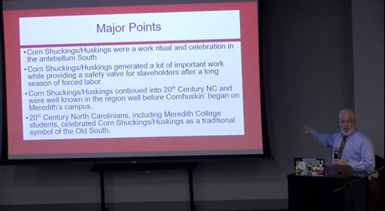 Daniel Fountain speaking in front of a presentation/PowerPoint screen