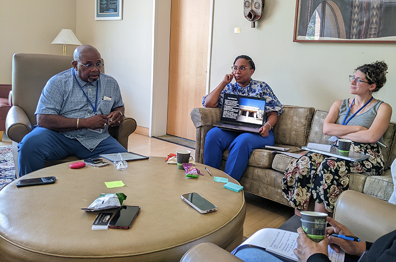 participants seated around a table with a laptop
