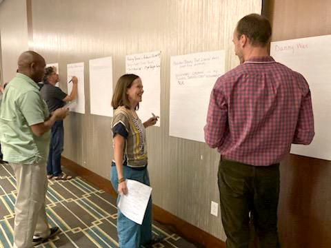 participants write on posters on wall