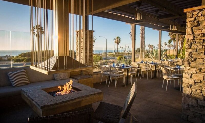 patio with tables, chairs, and fire pit