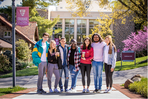 seven students standing outside on campus