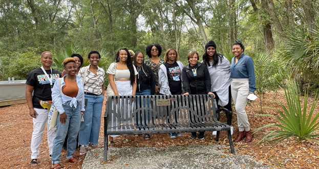 Students standing behind a bench with a commemorative marker