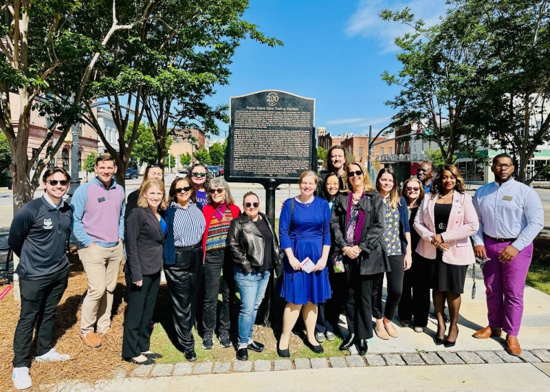 Group of Wesleyan students standing in front of a historical marker
