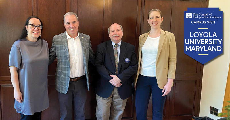 Three CIC staff stand with university official