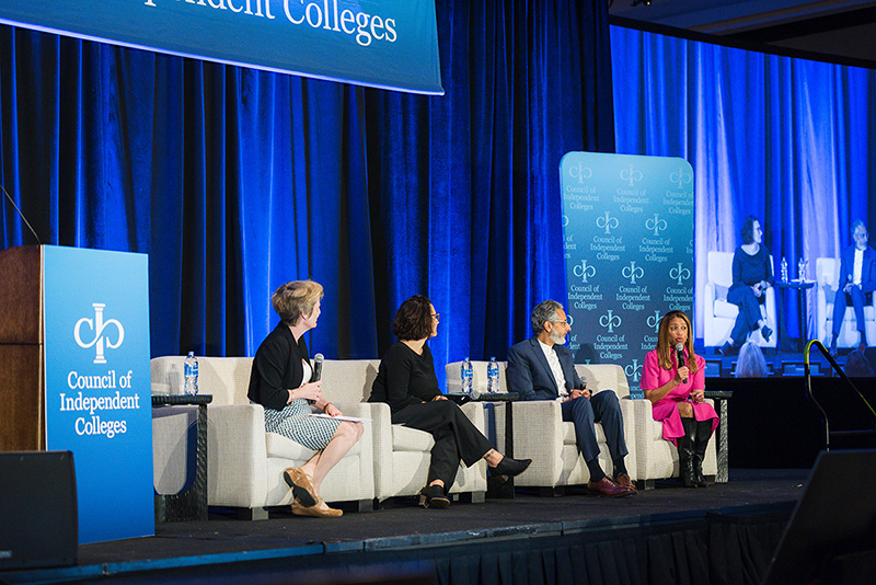 Four panelists present while seated on stage
