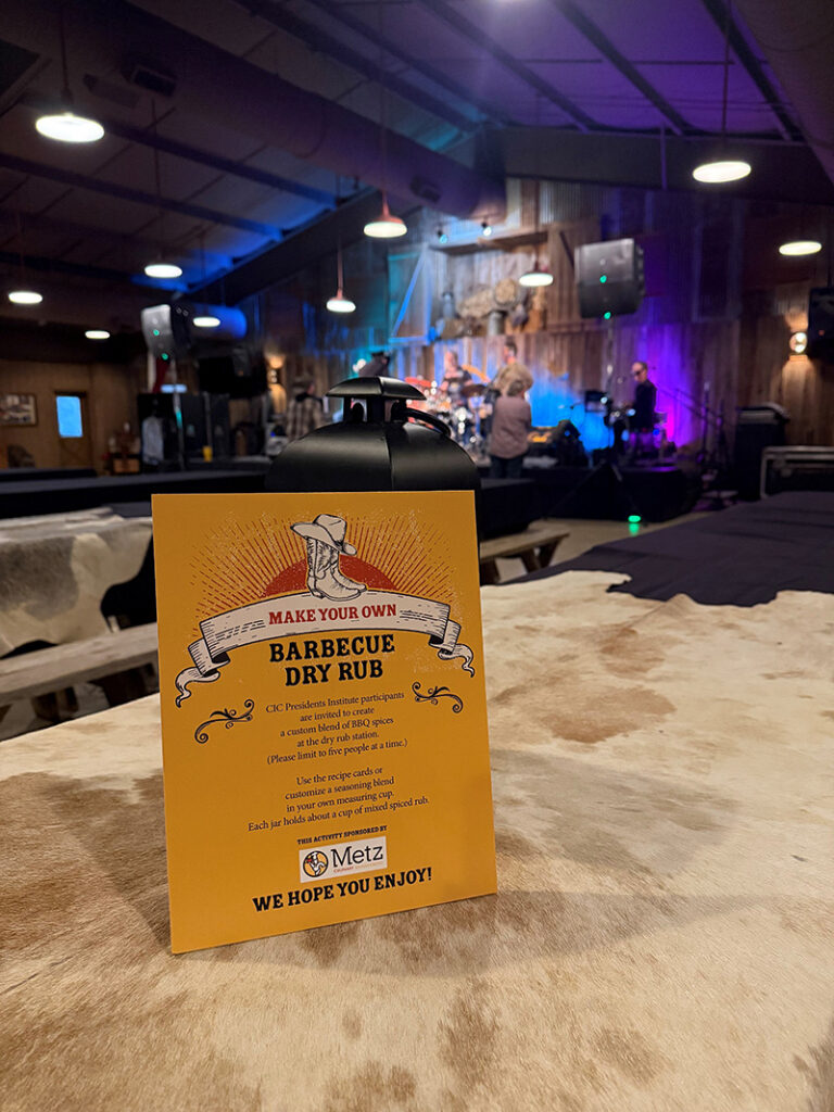 Sign for Make Your Own Barbecue Dry Rub on a cowhide covered table with live band in background on stage