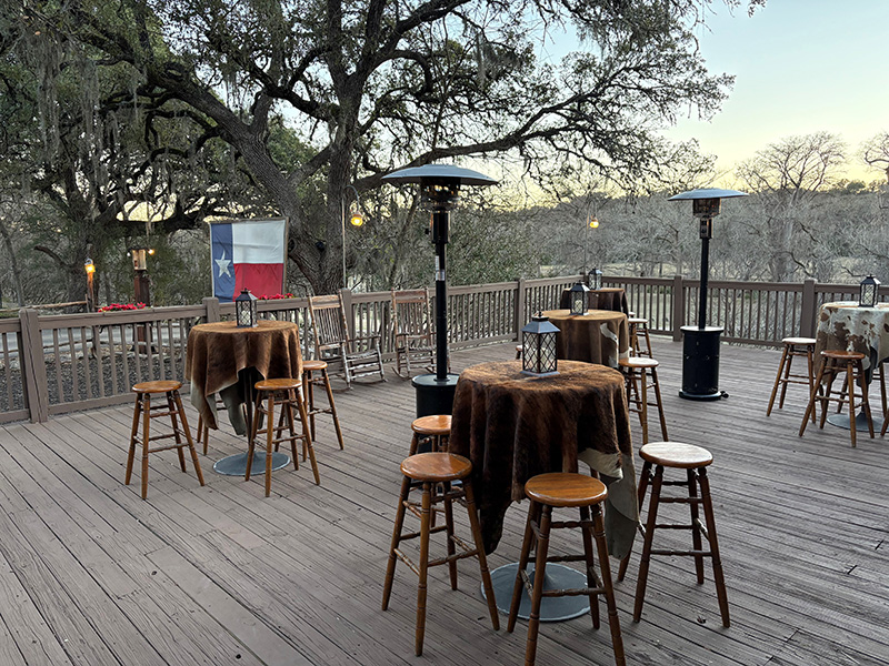 Outdoor seating at ranch with Texas flag in background