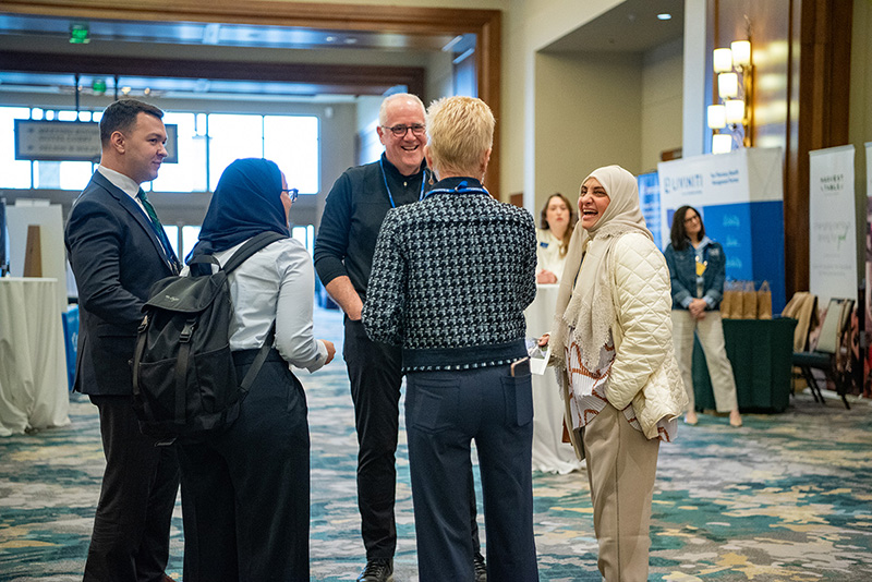 Participants speaking with sponsors in exhibit hall