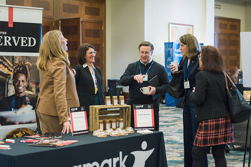 Participants speaking with sponsor representatives from Aramark