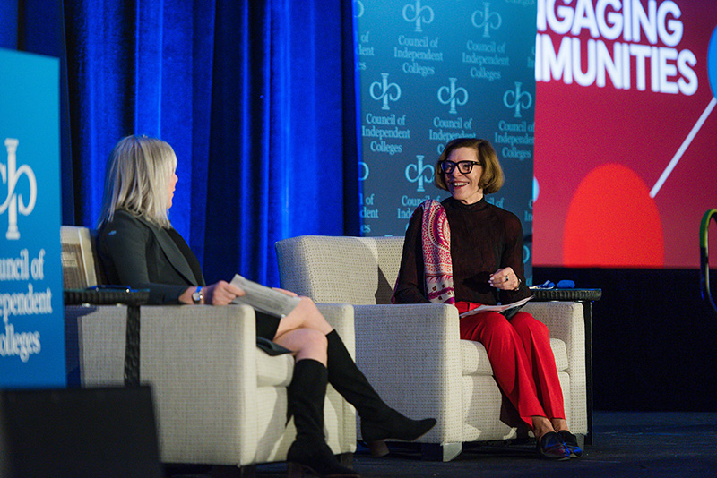 Barbara Mistick and Marjorie Hass present while seated on chairs on stage