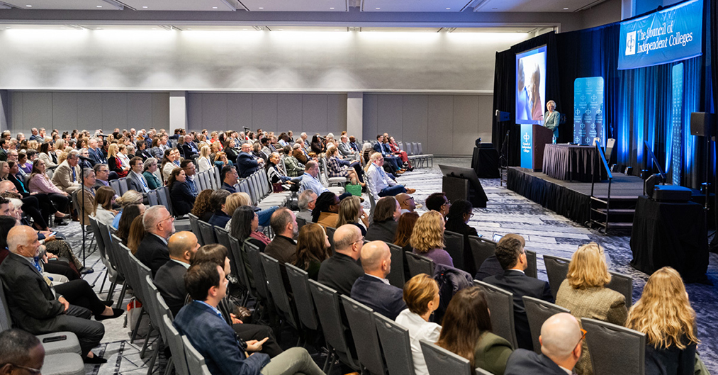 Plenary speaker presents from podium before seated audience
