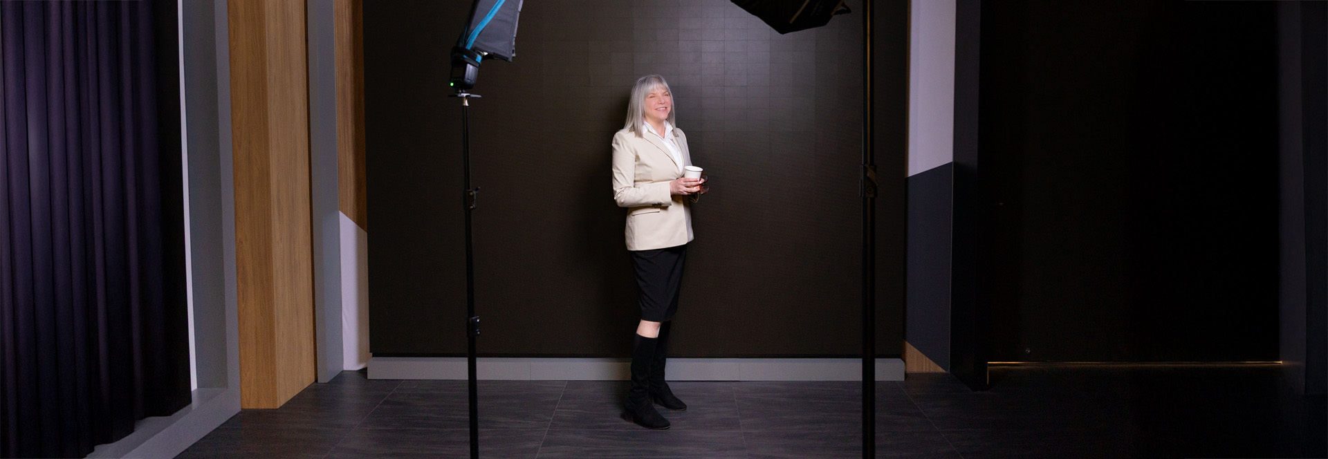 Marjorie Hass standing in a studio holding a cup